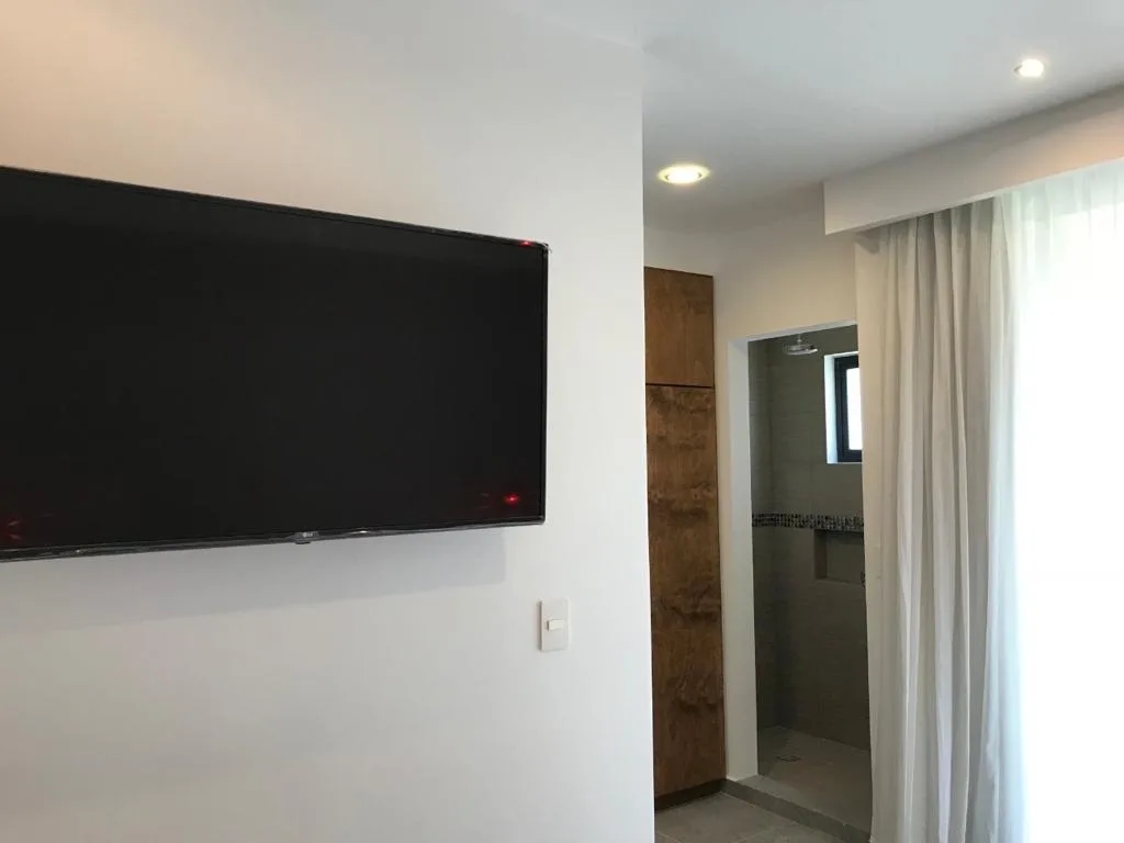 Living room with wall-mounted TV – 1-bedroom condo for rent on Fifth Avenue, Playa del Carmen