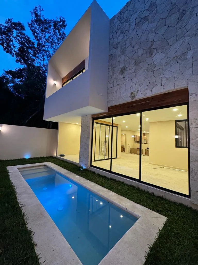 Backyard pool and glass doors at night – 3-bedroom house in Residencial Valenia, Playa del Carmen
