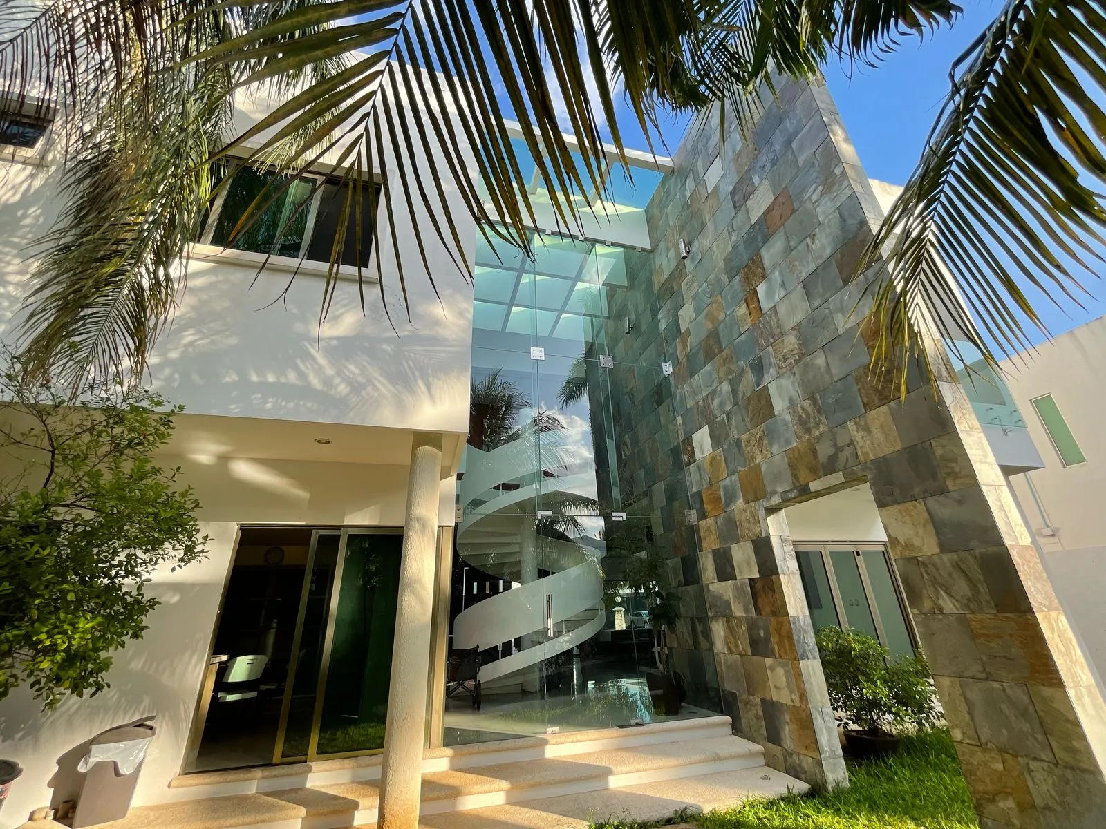 Rear facade with glass staircase and palm trees – 5-bedroom house in Villa Magna, Cancun