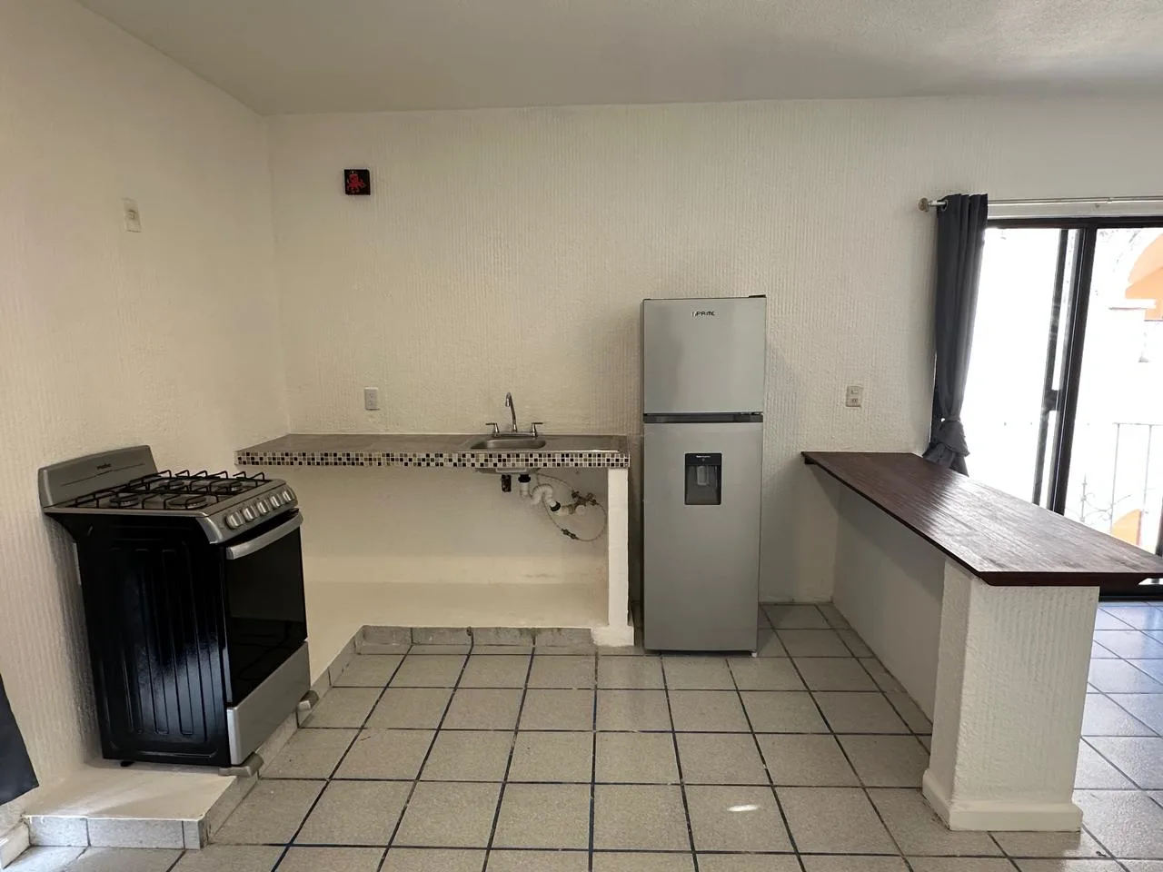Cocina con estufa y refrigerador – departamento de 2 recámaras en Cancún