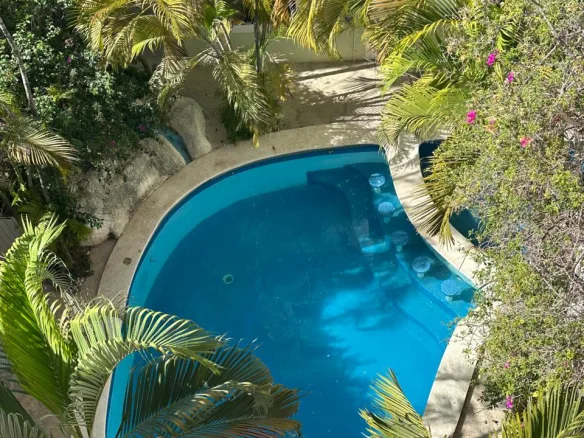 Alberca rodeada de jardines tropicales – departamento de 2 recámaras en Cancún